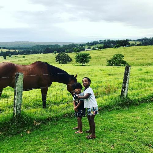 a man and a child standing next to a fence with a horse at Milton Woodstock Homestead Luxury retreat with NEW 11M POOL just minutes from the beach in Milton