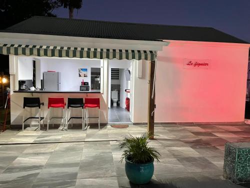 a patio with a bar with red bar stools at Domaine de Sainval in Sainte-Rose