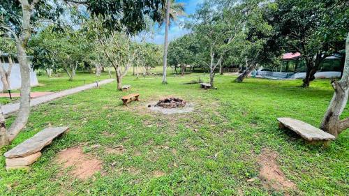 a park with benches and a fire in the grass at Commune18 Resort Chikmagalur in Chikmagalūr