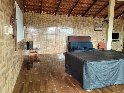 特林达迪SONHO DE CHACARA PIQUIA II的客房设有一张床,铺有木地板。