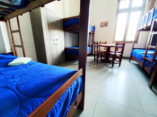 a bedroom with bunk beds and a table and chairs at Lima House Hostel in Lima
