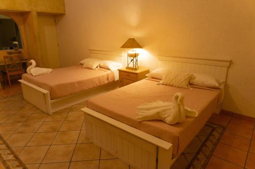 a bedroom with two beds with towels on them at Castillo San Carlos Lomas de Cocoyoc con Cancha de Padel 16Huespedes in Cocoyoc