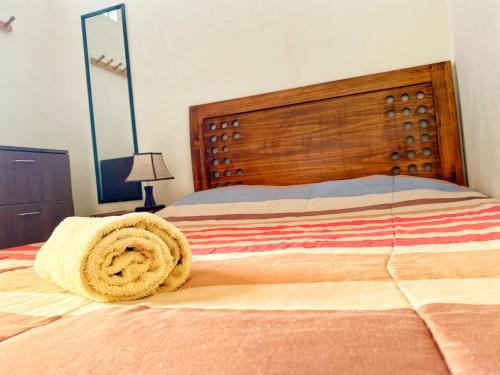 a bed with a large wooden headboard in a bedroom at Lima House Hostel in Lima