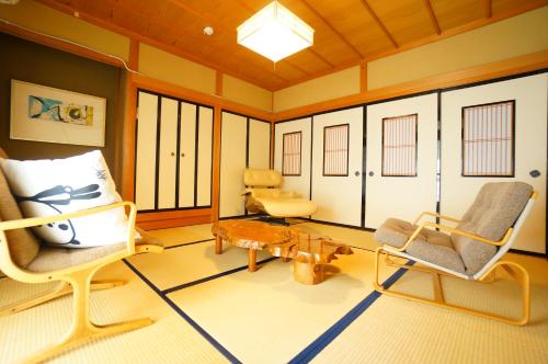 a living room with chairs and a coffee table at Tomato Villa Takayama Station in Takayama