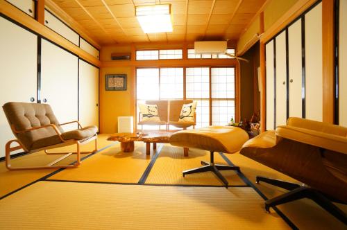 uma sala de estar com duas cadeiras e uma mesa em Tomato Villa Takayama Station em Takayama