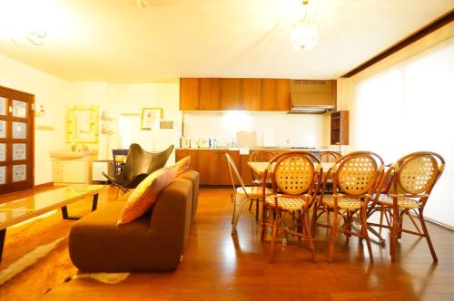 a living room with a couch and a table and chairs at Tomato Villa Takayama Station in Takayama