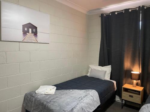 Postel nebo postele na pokoji v ubytování Gunnedah Serviced Apartments