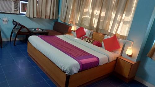 a bedroom with a bed with red pillows and a window at Hotel veersarthak residency in Hisār
