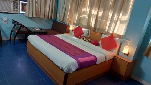 HisārにあるHotel veersarthak residencyのベッドルーム1室(赤い枕のベッド1台、窓付)