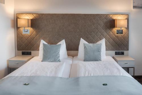 a hotel room with two beds and two lamps at Hotel Garni Möwe am See in Prien am Chiemsee
