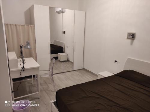 1 dormitorio con cama, escritorio y espejo en SWEET HOME en Milán