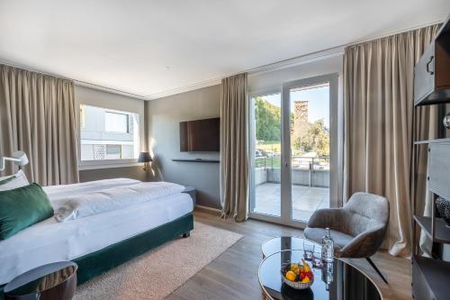 um quarto de hotel com uma cama e uma varanda em Monardo Hasenberg em Widen