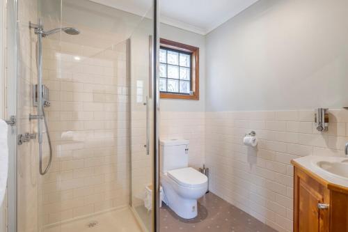 a bathroom with a toilet and a shower and a sink at Driftwood Cottages, Waterfront Studios in Dover