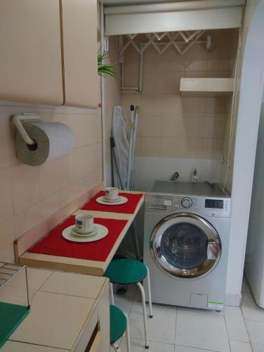 a kitchen with a washing machine with two cups on a counter at acogedor bonito min 2 noches aparta-estudio promoción totalmente independiente en la ciudad de Bogota en Colombia in Bogotá