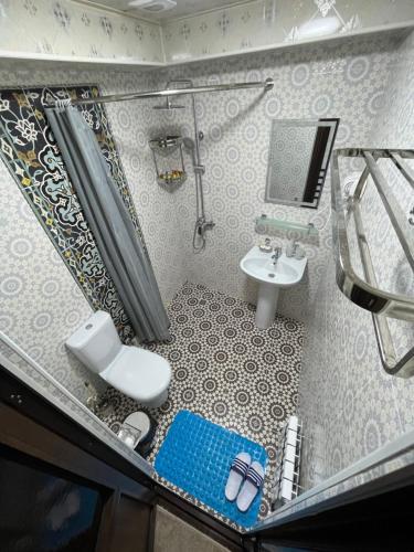 a small bathroom with a shower and a sink at Hotel Grand Marakand in Samarkand