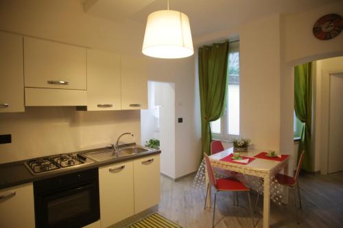 a kitchen with a sink and a table with a dining room at Casa San Vincenzo, un nido nel cuore di Genova. in Genova