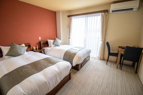 a hotel room with two beds and a window at Stay SAKURA Kyoto TSUBAKI in Kyoto