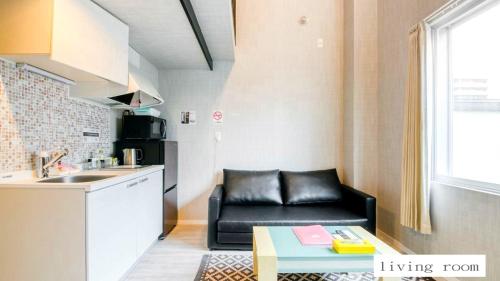 札幌市にあるAparthotel Palais Royal with Parkingのリビングルーム(黒いソファ付)、キッチン