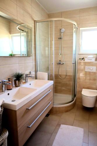 a bathroom with a shower and a sink and a toilet at Restful Kanica House in Rogoznica