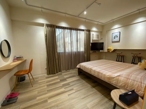 a hotel room with a bed and a television at Flower House in Tainan
