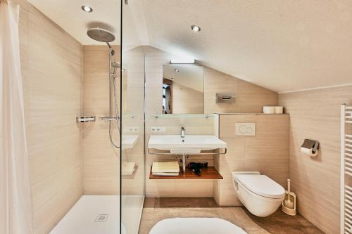 een badkamer met een toilet, een wastafel en een douche bij Chalet Rüfikopf in Lech am Arlberg