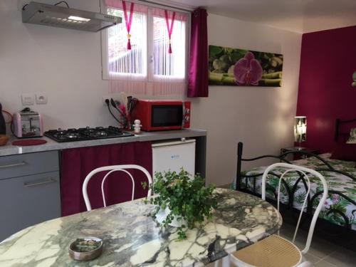 - une cuisine avec une table, des chaises et un lit dans l'établissement Gite des 2 arbres de la sagesse , agréable chalet avec spa privatif, à Ardentes