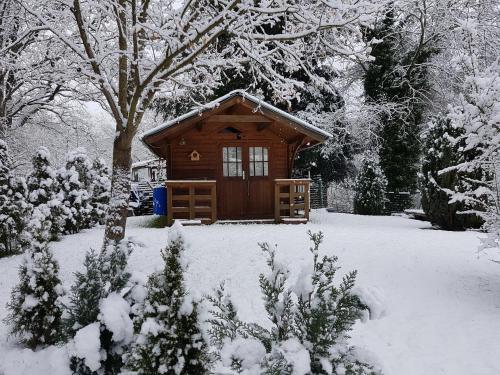 a small wooden cabin in a snow covered yard at Höllenbergblick in Spirkelbach