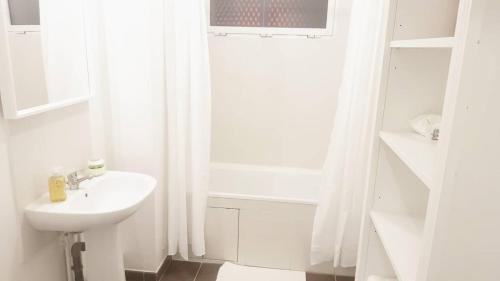 a white bathroom with a sink and a shower at 1 APPART 2 PIECES NEUF PROCHE GARE PARKING NETFLIX Evry Courcouronnes in Evry-Courcouronnes
