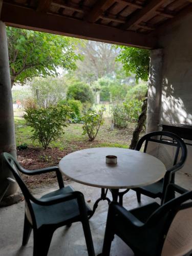 - une table et des chaises sur une terrasse couverte avec une tasse dans l'établissement La villa Bherte dé cil, à Aire-sur-lʼAdour