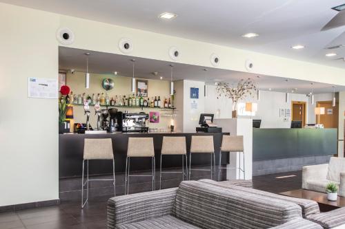 a bar with stools and a counter in a room at Holiday Inn Express Sant Cugat by IHG in Sant Cugat del Vallès