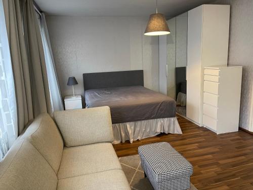 a bedroom with a bed and a couch and a chair at Apartment in Turku center in Turku