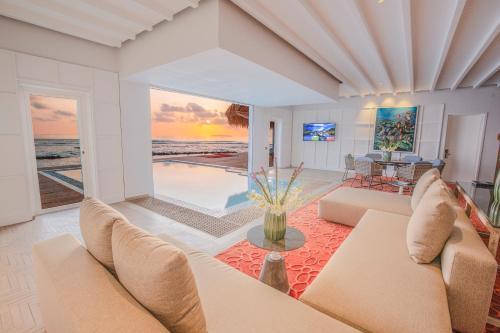 a living room with a view of the ocean at Emerald Maldives Resort & Spa-Deluxe All Inclusive in Raa Atoll