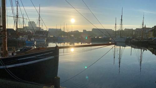 a group of boats docked in a marina at sunset at Villa Wiegand - a room with a view in Holbæk