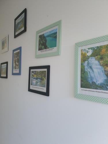 a group of framed pictures on a wall at "Le Petit Paradis" au Centre Ville d'Oyonnax in Oyonnax
