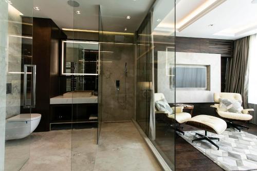 ein Bad mit einer Dusche, einem Schreibtisch und einem Waschbecken in der Unterkunft Truth Touch of Luxury in Belgrad