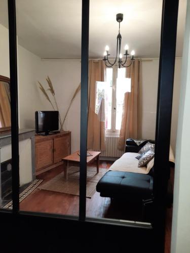 a living room with a bed and a couch and a window at La villa Bherte dé cil in Aire-sur-lʼAdour