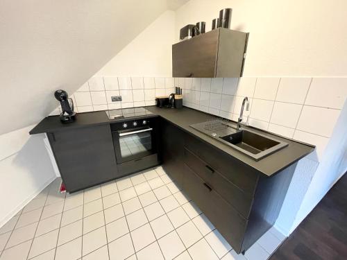 a small kitchen with a sink and a stove at Ferienwohnung Augenblick - Stylisches Apartment in der besten Altstadtlage von Erfurt in Erfurt