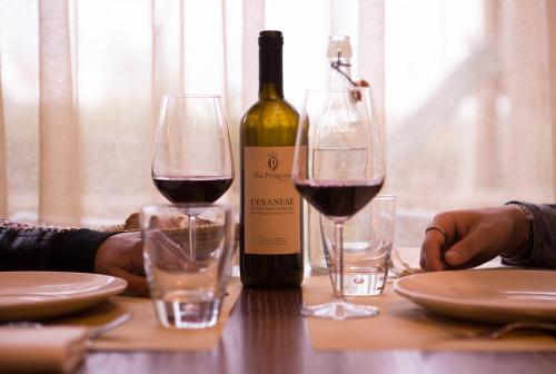 a bottle of wine and two glasses on a table at Dal Patricano in Frosinone