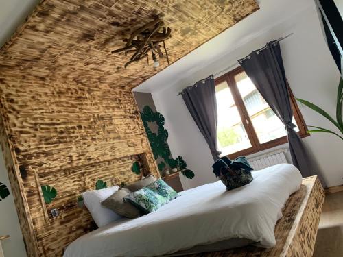 une chambre avec un grand lit avec un mur de briques dans l'établissement V&V lodge, à Alby-sur-Chéran