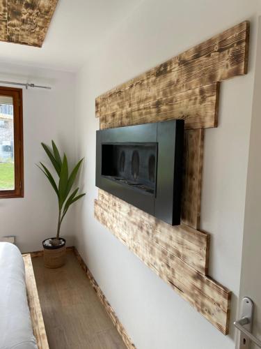 un salon avec une télévision sur un mur dans l'établissement V&V lodge, à Alby-sur-Chéran