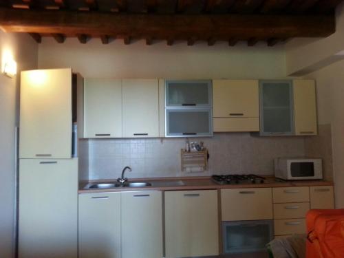 a kitchen with white cabinets and a sink at Il Poggio da Leo in Capanne