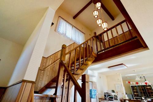 a large room with wooden stairs in a house at Healing space tajima Shinmoe in Kirishima