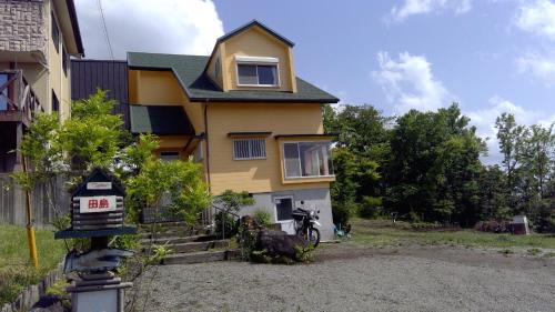 a yellow house with a sign in front of it at Healing space tajima Shinmoe in Kirishima
