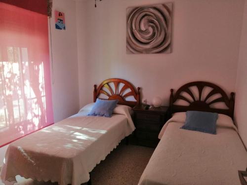 2 camas en una habitación con paredes rosas en Unifamiliar adosada con 3 dormitorios y 110m2, en Ronda