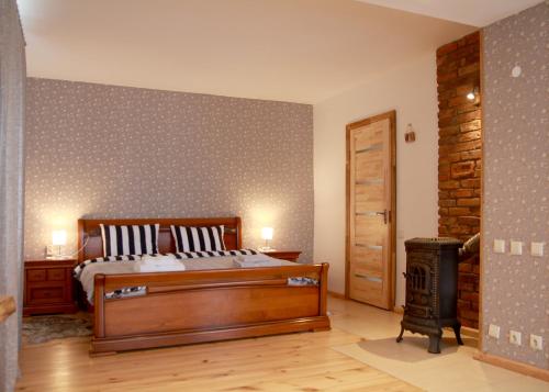 a bedroom with a bed and a wood stove at Emilie's Apartments in Liepāja