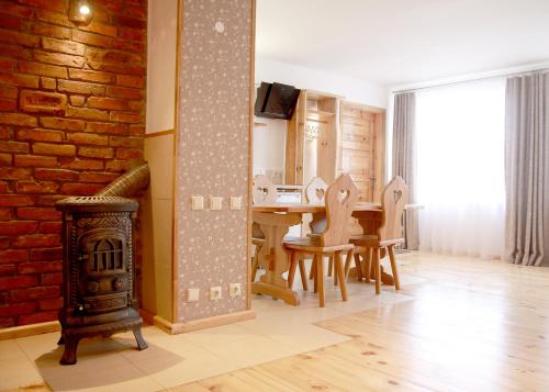 a dining room with a fireplace and a table with chairs at Emilie's Apartments in Liepāja