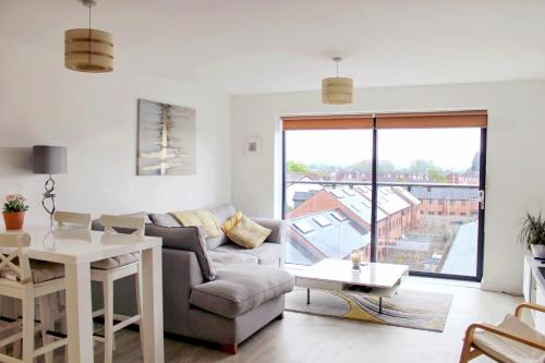 uma sala de estar com um sofá e uma mesa em Bridgewater House - Private Room & Bathroom Near Etihad and CoOp Arena em Manchester