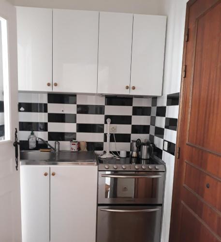 une cuisine avec des placards blancs et une cuisinière en acier inoxydable dans l'établissement Beauty, à Saint-Jean-Cap-Ferrat