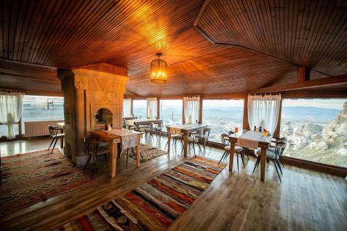 a living room with tables and chairs and a fireplace at Duven Hotel Cappadocia in Uchisar