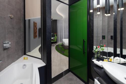 a bathroom with two sinks and a green door at Al Khoory Sky Garden Hotel in Dubai